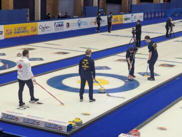 Sweden's Oskar Eriksson sweeps a curling stone delivered by Rasmus Wranaa, not pictured, while Simon Olofsson walks alongside during the sixth end of a game against Canada at the 2026 World Men's Curling Championship in Ogden, Utah, on Tuesday, March 31, 2026. (Ryan Olson, Standard-Examiner)
